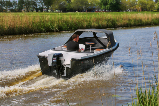 Achteraanzicht van de Reitdieper 550 XL sloep met Suzuki buitenboordmotor. Comfortabele gezinsboot met tafel en stuurconsole.