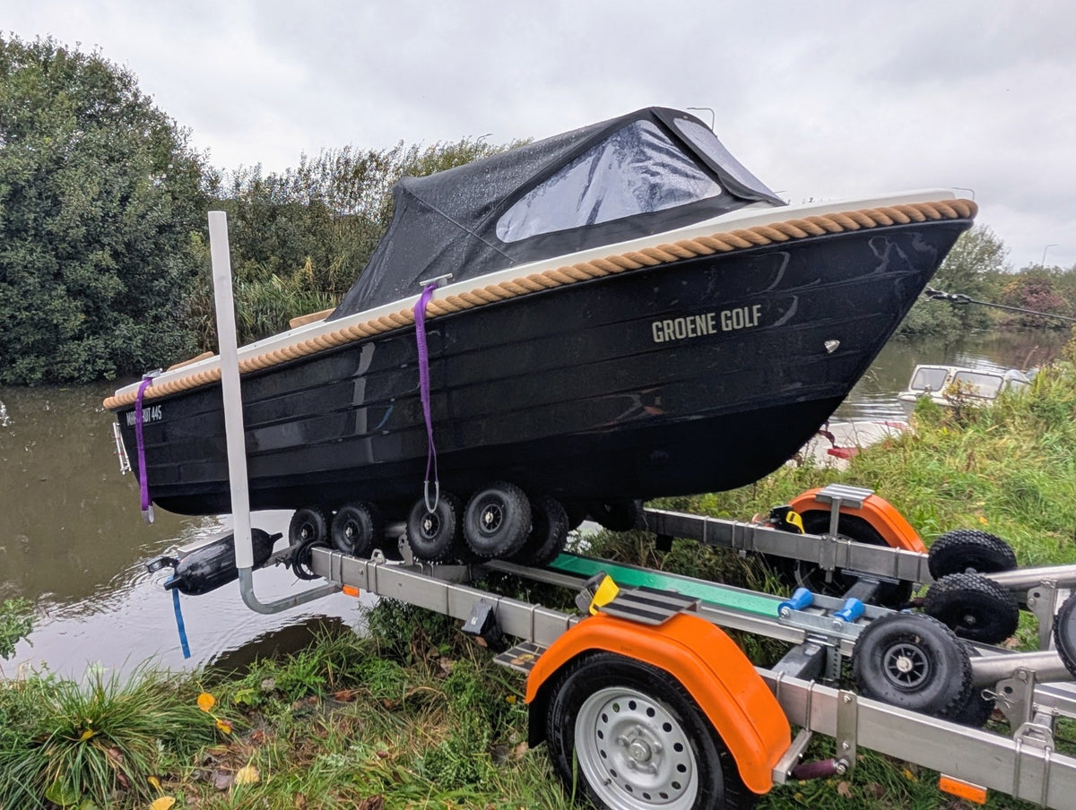 Zwarte Marinaut 445 sloep met buiskap op een boottrailer, zijaanzicht